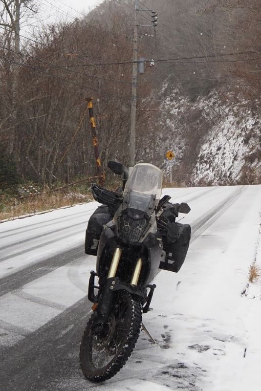 Motorcycle on snowy road near Marunuma Dam, Japan