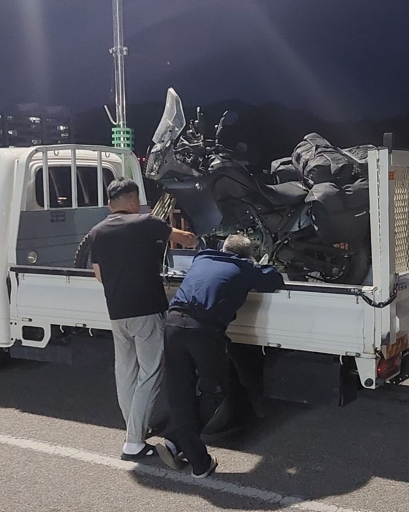Motorcycle in back of small truck, heading for Daegu to fix engine case