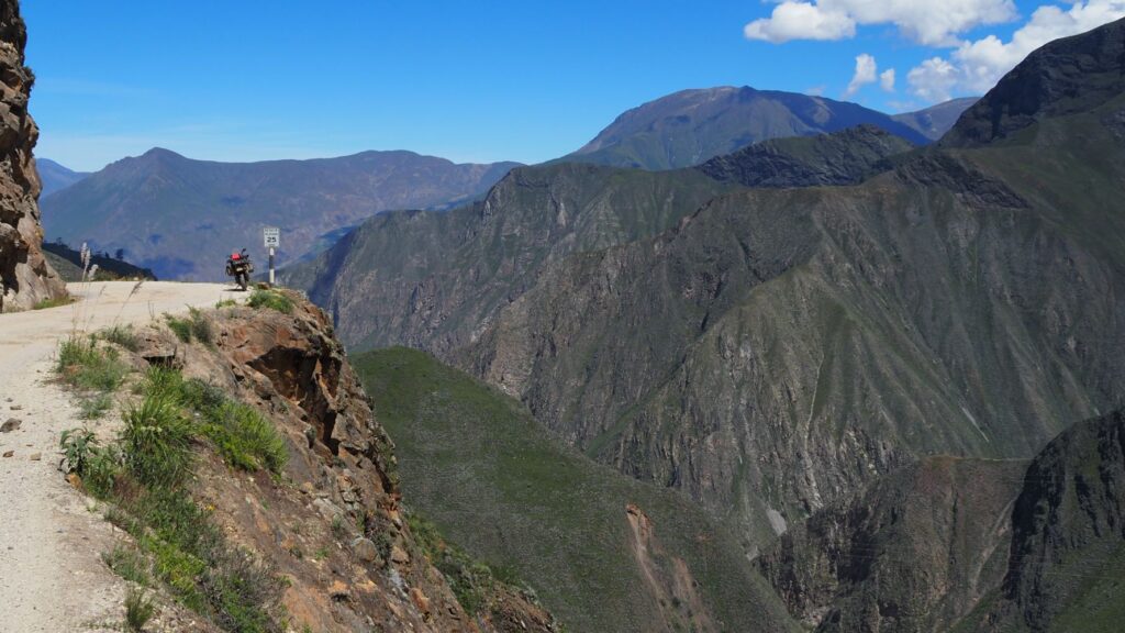 Motorcycle parked by steep cliff on road from Piscobamba to Trujillo. Peru